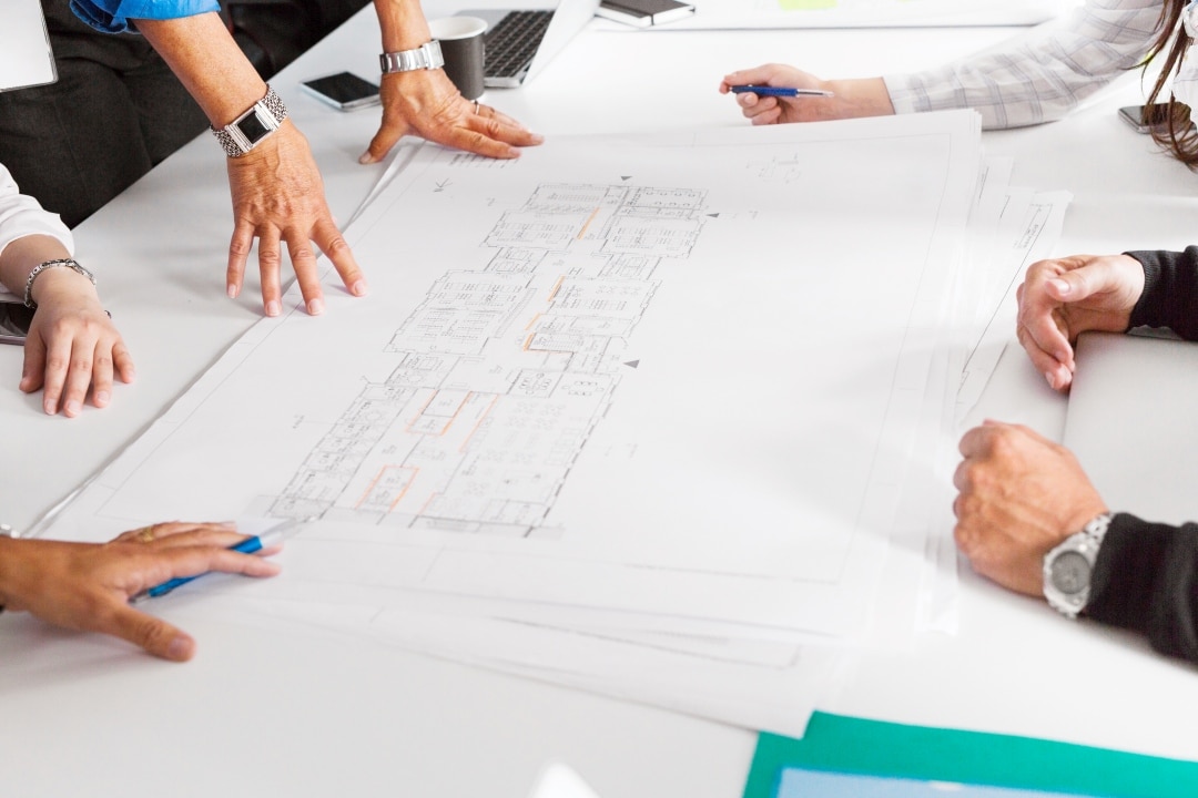 Collaborative Planning and Design Process with Development Team Team of architects and planners collaborating on development project blueprints and design processes