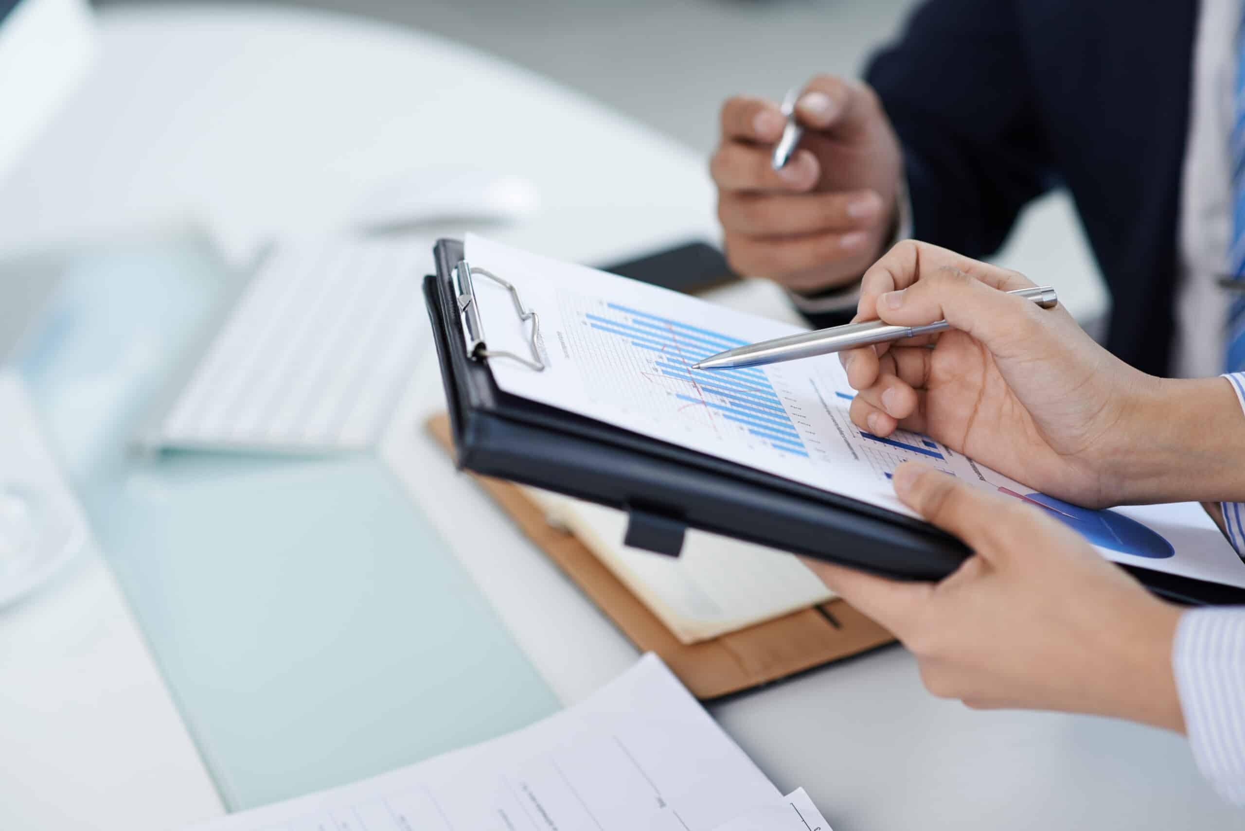 Business professional analyzing performance charts and compliance data for grant management and federal funding program oversight