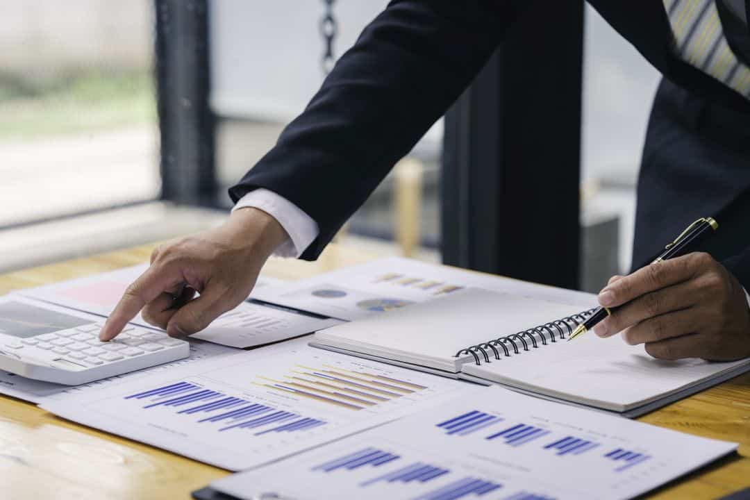 Financial analysis documents and investment planning charts showing industrial real estate development finance and ROI optimization strategies