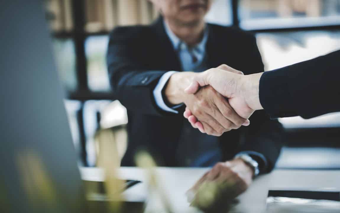 Business professionals collaborating on partnership agreement representing successful public-private partnership models for economic development projects
